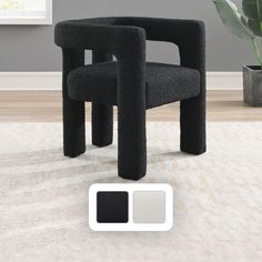 a black chair sitting on top of a white rug next to a potted plant