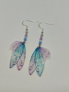 Discover the new sublime collection of resin fairy wing earrings. They were created with love, by me in my workshop. They will add a magical and magical touch to your day! * The earrings have 925 silver hooks. These high-end jewelry available in several colors are both elegant and durable. *The magical and magical fairy wings are made from resin which is a delicate but sturdy material once hardens. A certain light and shine has been incorporated thanks to the sequins which further adorn this sub Fairy Wing Earrings, Butterfly Fairy Wings, Magical Fairy, Butterfly Fairy, Fairy Wings, Wing Earrings, Pearl Charms, Ear Hook, Crystal Pearls