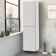 a white refrigerator freezer sitting in a kitchen next to a potted plant and window