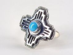 "Stunning Zia sun symbol sterling silver and turquoise ring handmade by Andre Van Dever, Navajo, from Running Bear Shop. This ring is size 6 and has a beautiful piece of turquoise. This ring measures 1.0\" inches tall and 1.0\" inches wide. Weight = 7 grams. Wonderful silver work and design. Signed by the shop on the back (RB inside a bear pictograph) and Sterling. Buy Authentic! A beautiful piece of wearable art from the Navajo Nation! A Certificate of Authenticity is available upon request at Sterling Silver Turquoise Ring With Concho, Unique Turquoise Ring With Concho For Gift, Gift Turquoise Ring With Concho, Southwestern Turquoise Concho Ring As A Gift, Southwestern Style Turquoise Concho Ring As Gift, Southwestern Concho Ring Jewelry, Navajo Jewelry Rings, Zia Sun Symbol, Unique Tuxedos