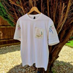 New design to my store ✨️  A plain white 100% cotton classic tshirt in a unisex size Large Unique modern tshirt with added Vintage linen fabrics.  The sleeves are made using a Vintage 1950s linen tablecloth that has delicate hand embroidered designs The patch on the front of the Tshirt is also Vintage 1950s embroidered linen  The tshirt itself is a very soft light cotton  Perfect for the warmer months with shorts or a skirt and then equally perfect for the cooler months under a Cardigan or jacke White Crew Neck T-shirt With Embroidered Logo, White Embroidered Relaxed Fit T-shirt, White Cotton T-shirt With Embroidered Text, White Embroidered Logo T-shirt For Summer, White Embroidered T-shirt For Summer, White Organic Cotton T-shirt, White Custom Embroidery Relaxed Fit Tops, White Relaxed Fit Top With Custom Embroidery, White Tops With Custom Embroidery Relaxed Fit