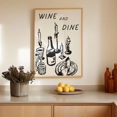 a kitchen counter with some lemons and bottles on top of it next to a framed wine and dine poster