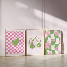 three framed art pieces in pink, green and white designs on wood floor next to wall