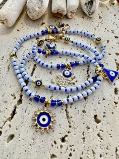 blue and white beaded bracelets with evil eye charms on them next to some garlic sticks