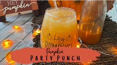 there is a drink in a glass on the table with lights around it and an orange sign that says hey dimming pumpkin party punch