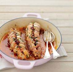 a pan filled with shrimp covered in sauce and garnished with parmesan