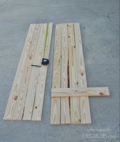 two pieces of wood laying next to each other on the ground with a measuring tape in between them