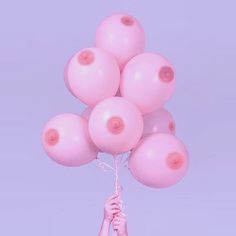 a bunch of pink balloons are being held by a person's hand in the air