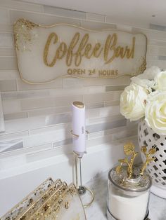 there is a coffee bar sign on the wall next to some cups and vases