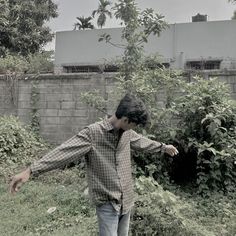 a man standing in front of a brick wall holding a camera up to his face