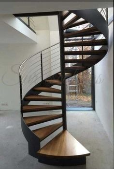 a wooden spiral staircase in an empty room