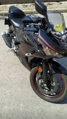 a black motorcycle parked on the street next to a curb with no one around it