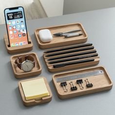 an assortment of office supplies sitting on a table next to a cell phone and pen holder