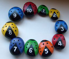 a group of colorful balls with numbers arranged in the shape of a circle on a white surface