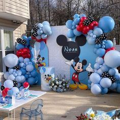 a mickey mouse balloon arch is decorated with balloons