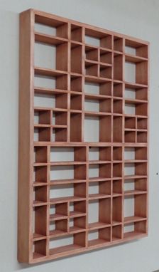 a wooden book shelf mounted to the side of a wall next to a white wall