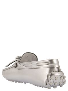 City Gommino moccasin Tod's Junior in refined silver-coloured leather, with hand-made topstitching and mask. Stamped Tod's monogram, iconic rubber sole with embossed rubber grommets. - Exposed handmade stitching - Embossed Tod's monogram - Faceplate - Leather lining - Rubber detail on the heel - Rubber sole with embossed rubber grommets DESIGNER ID: UXC00G00050SV0B200Composition: Upper: Leather Lining: Leather Sole: Leather + Rubber Luxury Driving Moccasins, Modern Silver Loafers With Round Toe, Classic Silver Loafers For Formal Wear, Classic Silver Loafers For Formal Occasions, Luxury Silver Loafers With Round Toe, Designer Silver Loafers With Leather Sole, Silver Leather Loafers With Round Toe, Classic Silver Loafers For Galas, Luxury Silver Loafers For Formal Occasions