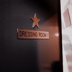 there is a sign that says dressing room 1 on the side of a wall with a star