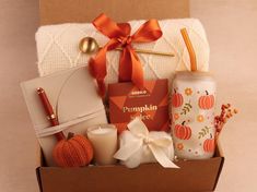 the pumpkin spice gift box is packed with candles and other items