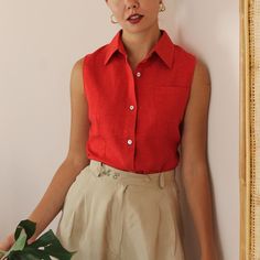 Vintage minimalist button-up shirt in a rich red shade. A beautiful classic sleeveless shirt! Collared with one chest pocket and mother of pearl button up fastening. Light weight, comfortable, and with a long length. Perfect for your everyday summer looks. BRAND: Times MATERIAL: 55% linen, 45% cotton **CONDITION: Excellent Vintage Condition **MEASUREMENTS: UK 10 / US 6 / EU 38 Our model's size is Small (UK 10, US 6, EU 38) NOTE: Our size recommendation is a guide only. Please refer to the measur Solid Sleeveless Shirt For Summer, Red Collared Blouse With Pockets, Red Summer Tops With Pockets, Red Summer Blouse With Pockets, Red Blouse With Pockets For Summer, Classic Sleeveless Summer Shirt, Classic Sleeveless Buttoned Blouse, Classic Sleeveless Blouse With Buttons, Classic Red Sleeveless Top