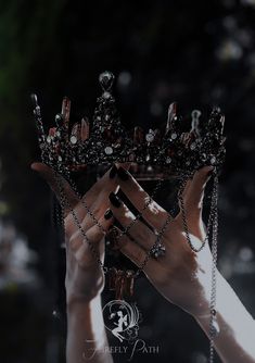 a woman holding up a tiara in front of her face