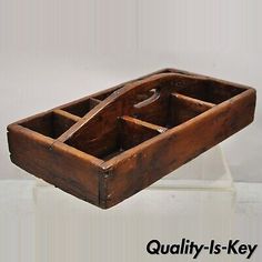 an old wooden box with two compartments on the bottom and one in the middle, sitting on