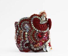 This beautiful red crystal cuff is made from tones of rhinestones, swarovski crystal and vintage treasure; in shades of reds and pinks with clear crystals.Just be gorgeous on your wedding day! This Statement piece will complete your bridal ensemble or add sparkle to any other special occasion.* Cuff Features*Completely unique Just over 2 1/2'' wide at widest pointLined in soft leatherClasp closure or ribbon bow tie in red Fits most wrist or I can make fit you specially just give me your wrist si Luxury Red Rhinestone Jewelry, Red Cuff Bracelet For Wedding, Red Jeweled Bracelet For Party, Red Crystal Bracelet For Wedding, Red Adjustable Cuff Bracelet For Wedding, Red Embellished Party Jewelry, Adjustable Red Cuff Bracelet For Wedding, Red Rhinestone Bracelets For Party, Red Crystal Bracelets With Rhinestones