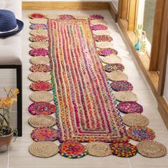 a colorful rug is on the floor next to a potted plant