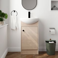 a bathroom with a sink, mirror and trash can