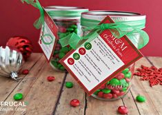 two glass jars filled with candy sitting on top of a wooden table next to christmas decorations