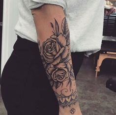 a woman's arm with a rose tattoo on the left side of her arm