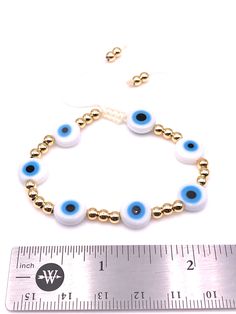 "Evil Eye White Beads Bracelet This is a Handmade Bracelet. Features Glass Bead Diameter: 0.3\" Inches/1cm, 7 Flat round white evil eyes separated with a 4 mm Gold Plated balls over 1 mm white nylon cotton cord. It is adjustable from 6 to 8 inches approximately. It is carefully shipped in a beautiful organza pouch, bubble wrapped and well protected. 100% Satisfaction Guarantee. **Leslie Boules is a brand that is born from the desire to create new jewelry accessories that accompany us daily, make White Beads Bracelet, Turkish Eye, Blue Beaded Bracelets, Evil Eye Pendant, Adjustable Necklace, Lariat Necklace, Eye Jewelry, White Beads, Newborn Gifts