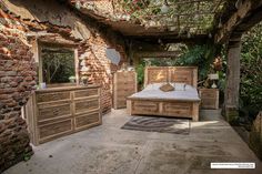 a bedroom with brick walls and wooden furniture