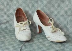 One pair of very cute Antique circa 1940s 1950s white Leather Woman's Shoes.  The shoes feature a very cute pierced detail & original silky rayon laces.    Perfect Wedding-Nurse Athletic Shoes. Period Costume. These shoes are in AS FOUND vintage condition, one of the shoes has significant damage-as shown.  I am selling for study, repair or restoration.   Bottom soles are leather, they do show wear.    Approx Measurements- 9" heel to toe exterior measurement 2 3/4" across bottom sole at widest point,2 3/4 inch heel- these measurements are taken on the outside of the shoes. Please check out the photos as this is part of the description.  They are still sturdy and wearable for the right size foot or would make a great prop.  There are no returns due to size, fit or color-Please ask questions. 1910s Shoes, 1950s Shoes, 1940s Shoes, White Leather Shoes, Shoes Vintage, Period Costumes, 4 Inch Heels, Vintage Shoes, Womens Heels