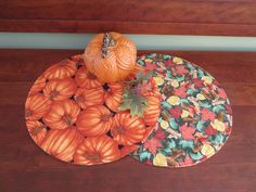 two plates with pumpkins on them sitting on a wooden table next to each other