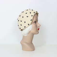 "Vintage 1960s Mr. John hat in a cream felted wool with prong set black metal half moons and silver rhinestones for stars.  Fitted cloche style that hugs the head and dips down over the ears.  Soft and pliable with a wired brim and interior grosgrain ribbon.  ♦ MEASUREMENTS ♦ Inner circumference - 22.5\" Depth - 4.5\" at the front and 5\" at the sides Materials - felted wool, rhinestones, metal moons Label - Mr. John Classic Colors - cream, black and silver Condition - very good, a few scattered Moon Hat, Rhinestone Hat, Half Moons, Novelty Hats, 60s Mod, Cloche Hat, Toiletry Bag Travel, Felted Wool, Silver Rhinestone