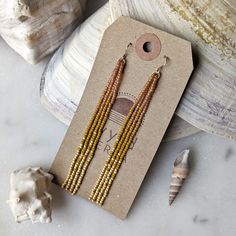 The most dreamy sun kissed inspired color combination! These earrings have the most gorgeous peachy and lavish gold feel to them. Inspired by those sunny days at the beach when the sun is reflecting off the water like diamonds. Beautifully dramatic, comfortably lightweight. Enjoy the playful, free flowing style of beaded fringe earrings, without the weight. Featuring 4 strands of hand woven matte and frosted glass beads. These unique glass beads have a very luxe look and feel to them. Colors: Th Elegant Yellow Jewelry For The Beach, Elegant Yellow Beach Jewelry, Orange Drop Earrings For The Beach, Orange Drop Earrings For Beach, Summer Gold Beaded Jewelry, Summer Gold Beads Drop Earrings, Adjustable Gold Beaded Earrings For Beach, Summer Dangle Jewelry With Gold Beads, Yellow Gold Drop Earrings For Summer