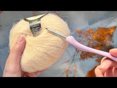 a person is knitting yarn with a needle