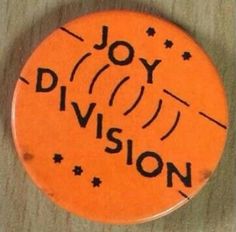 an orange button with the words joy division written on it and stars in black ink