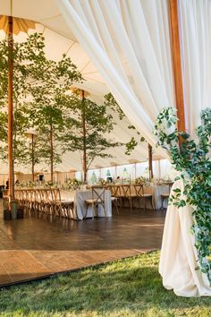 the inside of a tent with tables and chairs