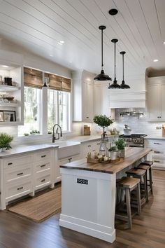 a large kitchen with white cabinets and wooden counter tops, along with an island in the middle