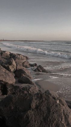 a person standing on rocks near the ocean