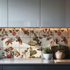 the kitchen counter is decorated with flowers and butterflies on it's tile backsplash