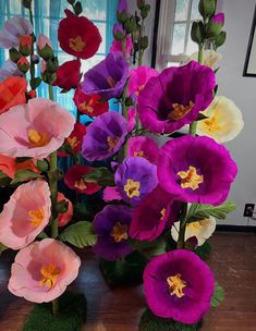 there are many different colored flowers in the vases on the table with mossies