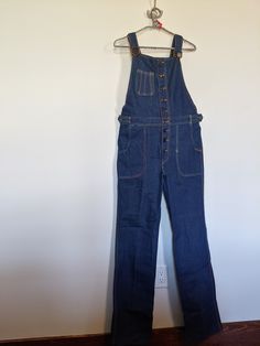 "Vintage Frederick's of Hollywood 1970's Overalls, 100% Cotton- No- Stretch, Adjustable Shoulder Straps Zipper Front, Two Setting Button Flaps at Waist,  Mint Vintage Condition, Never Worn or  Washed, Tag Reads L 31, Flat Measurements: Waist 32\" 1st.Button , 2nd Button 28\" 9 Front Buttons, Inseam 34\", 22\" Top Of Bid to Crotch, 34\" Hips, 8\" Wide Bottom Leg  Shoulder Strap Length 16\" to 29\" Very Cute. (909)" Retro Workwear Jeans For Fall, Retro Fall Jeans For Office, Retro Cotton Jeans With Button Closure, Vintage Spring Workwear Overalls, Retro Cotton Jeans With Buttons, Vintage Spring Workwear Jeans, Retro Medium Wash Jeans With Buttons, Retro High Rise Jeans For Workwear, Vintage Jeans For Fall