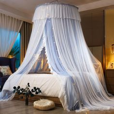 a canopy bed with white drapes and lights on the ceiling is in a bedroom