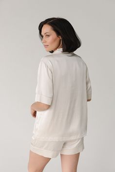 This Silk Short Sleeve Pajama Top glides over your skin with 100% mulberry silk treated with aloe vera for a silky-soft, soothing feel. Luxurious, lightweight, and loose-fitting throughout, this classic pajama top elevates any nightly routine. With elegant details like mulberry silk flat piping, inner French seams, logo engraved shell buttons, and an eco-friendly plated logo charm. Pair it with our women's silk pajama shorts or women's silk pajama pants for the ultimate silk sleep set. DETAILS: Silk Pajamas Shorts, Silk Pajama Pants, Nightly Routine, Silk Pajamas Women, Comfortable Loungewear, Classic Pajamas, Silk Pajama, Event Outfit, Sleep Set