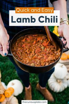 a person holding a pan full of food with the words quick and easy lamb chili