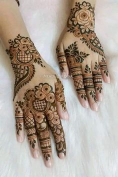 two hands with henna designs on them