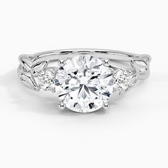 a white gold engagement ring with an oval center stone surrounded by three smaller round diamonds